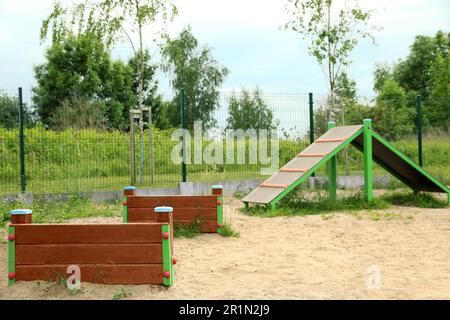 Un véhicule en bois surmonte et monte la colline sur une aire d'entraînement des animaux en plein air Banque D'Images