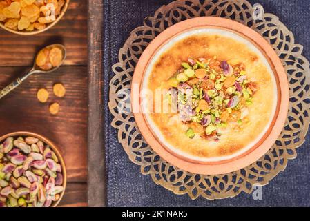 Cuisine arabe ; dessert égyptien traditionnel « Om Ali » ou « Umm Ali » de pain trempé, de lait et d'une charge de noix grillées et de raisins secs. Vue de dessus avec gros plan. Banque D'Images