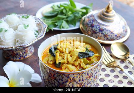 Le curry de crabe thaïlandais et le betel partent en porcelaine Benjarong avec vermicelles de riz sur fond de bois - le curry de style Phuket appelé Kang Poo Banque D'Images