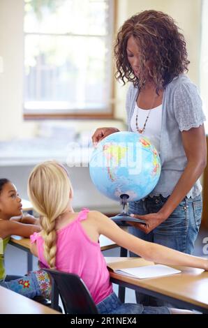 Globe, femme enseignante et enfants en classe pour l'éducation en géographie, l'apprentissage du monde et la connaissance de la terre. Personne africaine avec enfants d'école pour Banque D'Images