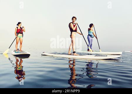 Un groupe de paddle-boardeurs de stand-up sur un matin brumeux à Casco Bay Banque D'Images