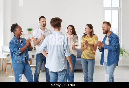 Des amis enthousiastes et joyeux applaudissent l'homme exprimant leur respect et le félicitant pour la victoire. Banque D'Images