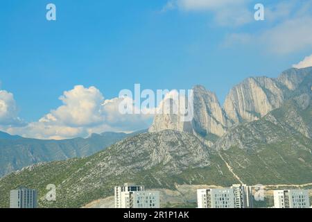 Ville près des montagnes sous ciel bleu avec nuages Banque D'Images