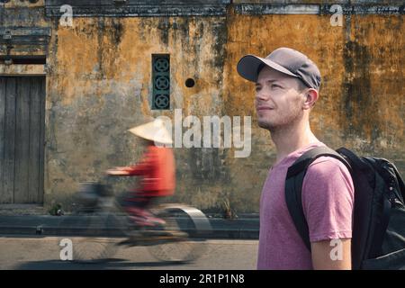 Portrait de voyageur avec sac à dos. Homme explorant les rues de la ville antique de Hoi an au Vietnam. Banque D'Images