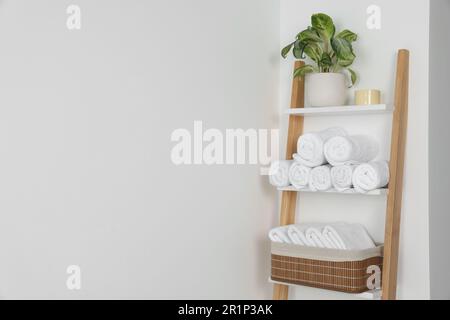 Serviettes souples sur échelle décorative près du mur blanc, espace pour le texte Banque D'Images