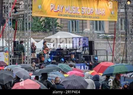 Des spectateurs tenant des parapluies assistent au concert pour la paix organisé par la Communauté de Sant'Egidio. "Play Music Stop War" sur la Piazza del Popolo, la deuxième édition du marathon de musique organisé par la Communauté de Sant'Egidio pour dire non à la guerre en Ukraine et à toutes les guerres. Les finalistes du concours de musique "Play Music Stop violence", promu par le mouvement Jeunesse pour la paix, étaient également sur scène: De jeunes artistes et groupes émergents ont proposé leurs chansons originales au nom de la paix, de la solidarité et de l'inclusion. La Communauté de Sant'Egidio est un mouvement laïc d'inspiration chrétienne catholique, dédié Banque D'Images