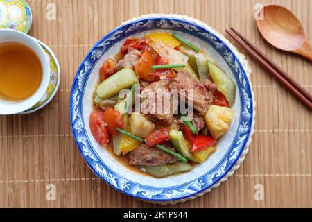 Porc doux et aigre - plat chinois célèbre sur platemat de bambou Banque D'Images