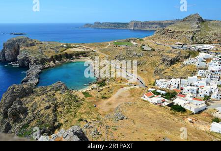 Vue d'en haut sur la baie de l'Apôtre Paul à Lindos, sur l'île de Rhodes. La route passe à côté de la baie. La baie est en forme de coeur. Banque D'Images