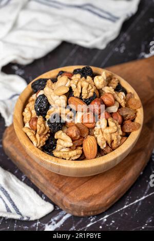 Noix brutes mélangées. Écrous spéciaux mélangés dans le bol. Noisette, amande, noix de cajou, pistache, bleuet séché. Super-alimentation. Concept de cuisine végétarienne. des collations saines. Banque D'Images