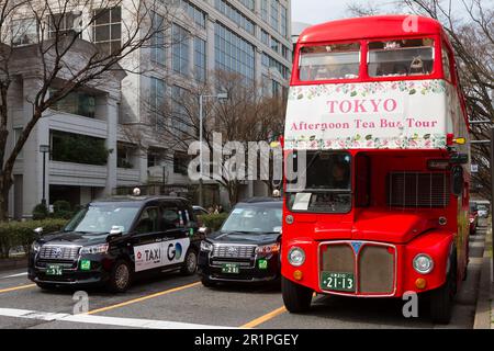 Un bus rouge Routemaster de Londres offrant des visites saisonnières en bus de thé l'après-midi dans une rue avec deux taxis JPN, Omotesando, Tokyo, Japon. Banque D'Images