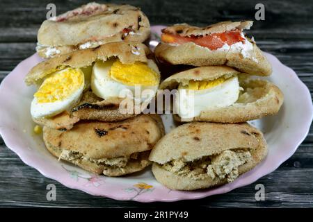 Une assiette de sandwiches au fromage blanc Feta avec des tranches de tomates, de la tahini halva traditionnelle ou Halawa Tahiniya et des tranches d'œufs durs insi Banque D'Images