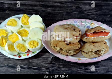 Une assiette de tranches d'œufs durs et de sandwiches au fromage blanc Feta avec des tranches de tomates et des tahini halva ou Halawa Tahiniya Banque D'Images