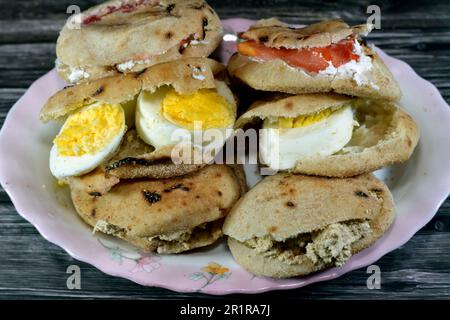 Une assiette de sandwiches au fromage blanc Feta avec des tranches de tomates, de la tahini halva traditionnelle ou Halawa Tahiniya et des tranches d'œufs durs insi Banque D'Images