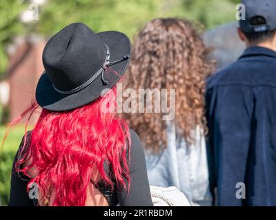 Vue arrière avec une femme à tête rouge non identifiée portant un chapeau noir. Belle femme dans le parc Banque D'Images
