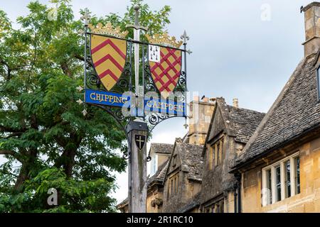 Chipping Campden, Royaume-Uni-août 2022 ; vue à angle bas des boucliers de la ville de fer à souder avec une épée sur un poteau en bois au début de la voie Cotswold Banque D'Images