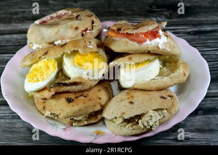 Une assiette de sandwiches au fromage blanc Feta avec des tranches de tomates, de la tahini halva traditionnelle ou Halawa Tahiniya et des tranches d'œufs durs insi Banque D'Images