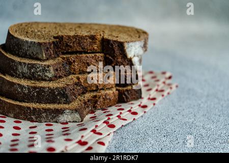 Pile de tranches de pain de levain de seigle foncé sur une serviette pliée Banque D'Images