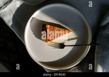 Vue en hauteur d'une tranche de Cheesecake basque brûlé sur une assiette Banque D'Images