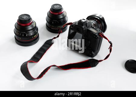 Équipement de photographie moderne, photocamera professionnelle avec écran vide pour le design de maquette et objectifs sur table blanche Banque D'Images