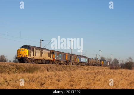 Services ferroviaires directs locomotives diesel numéros 37601, 20307, 20313 et 57009 haut et queue avec train de traitement de tête de rail de travail 37667 près de Marks Tey. Banque D'Images