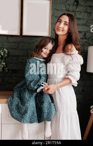 Fête des mères. Une jeune maman sensible embrasse sa petite fille adorable à la maison. Confiance, soutien et amour entre maman et enfant. Une famille aimante Banque D'Images