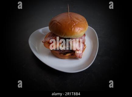 Hamburger maison dans un petit pain avec bacon et fromage Banque D'Images