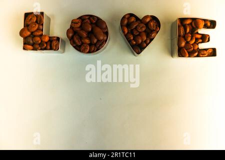 Belle texture avec le mot amour pour l'inscription du jour de la Saint-Valentin faite de grains de café Arabica naturels bruns grillés sélectionnés, robusta C Banque D'Images