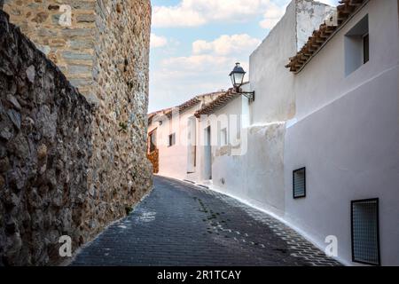 Petite rue escarpée dans la vieille ville de Moratalla, Murcie, Espagne, avec maisons blanchies à la chaux et mur médiéval Banque D'Images