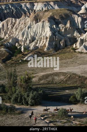 Balade à cheval parmi les rochers d'une forme inhabituelle de roche volcanique dans les environs du village de Göreme dans la région de Cappadoce en Turquie. Banque D'Images