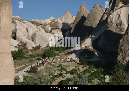 Balade à cheval parmi les rochers d'une forme inhabituelle de roche volcanique dans les environs du village de Göreme dans la région de Cappadoce en Turquie. Banque D'Images