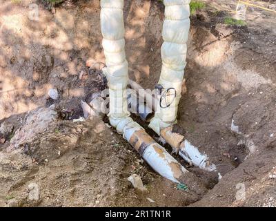 installation de communications souterraines pour les bâtiments résidentiels. tuyaux de plomberie en noir avec une énorme soupape blanche pour réguler le débit d'eau. Banque D'Images