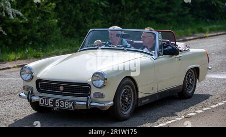 Stoke Goldington, Northants, Royaume-Uni - 14 mai 2023. 1971 mg de blanc MIDGET classique voiture de sport britannique traversant un village anglais Banque D'Images