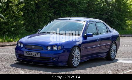 Stoke Goldington, Northants, Royaume-Uni - 14 mai 2023. 2000 voiture classique bleue FORD MONDEO qui traverse un village anglais Banque D'Images