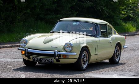 Stoke Goldington, Northants, Royaume-Uni - 14 mai 2023. 1970 jaune TRIOMPHE GT6 voiture de sport classique conduite à travers un village anglais Banque D'Images