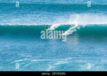 Les grandes vagues se brisent et créent de la mousse blanche qui se vaporise dans l'air. Plage de Sopelana près de Bilbao. Deux surfeurs se rassemblent sur la même vague. Banque D'Images