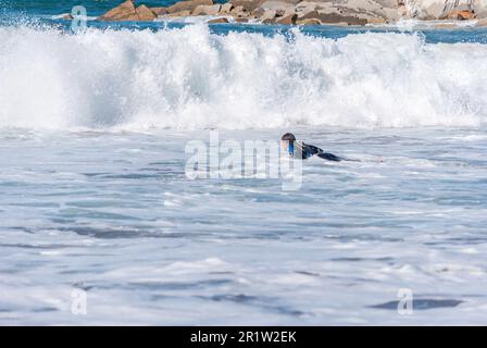 Les grandes vagues se brisent et créent de la mousse blanche qui se vaporise dans l'air. Plage de Sopelana près de Bilbao. Les surfeurs attendent la vague parfaite. Banque D'Images