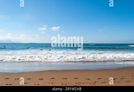 Les grandes vagues se brisent et créent de la mousse blanche qui se vaporise dans l'air. Plage de Sopelana près de Bilbao. Les surfeurs attendent la vague parfaite. Empreintes. Banque D'Images