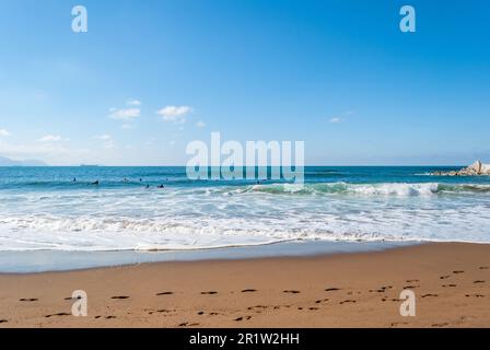 Les grandes vagues se brisent et créent de la mousse blanche qui se vaporise dans l'air. Plage de Sopelana près de Bilbao. Les surfeurs attendent la vague parfaite. Empreintes. Banque D'Images