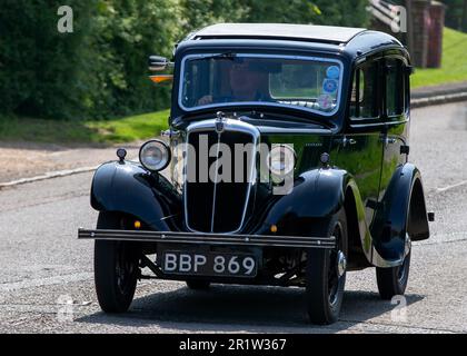 Stoke Goldington, Northants, Royaume-Uni - 14 mai 2023. 1935 MORRIS HUIT voitures d'époque traversant un village anglais Banque D'Images