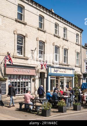 Personnes assises à l'extérieur du salon de thé Posthorn à Leyburn, dans le North Yorkshire, en Angleterre, au Royaume-Uni Banque D'Images