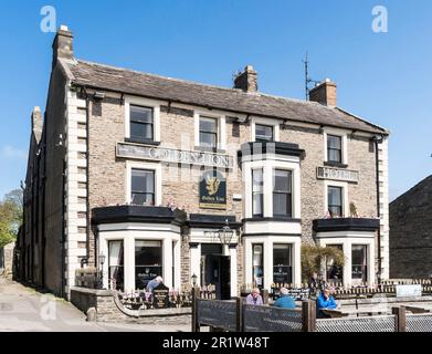 Les gens assis à l'extérieur du pub Golden Lion à Leyburn, dans le North Yorkshire, en Angleterre, au Royaume-Uni Banque D'Images