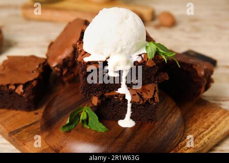 Planche avec des morceaux de chocolat savoureux brownie et de crème glacée sur la table Banque D'Images