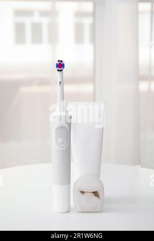 Brosse à dents électrique avec pâte sur la table dans la chambre Banque D'Images