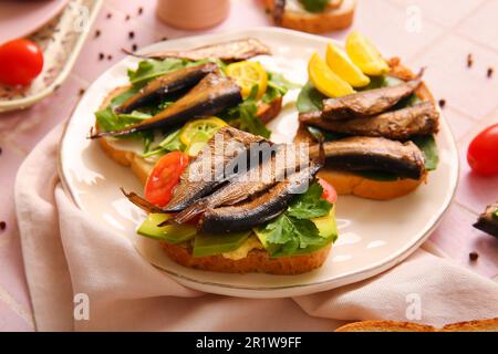 Assiette de délicieux sandwiches avec des sparats fumés en conserve sur la table Banque D'Images