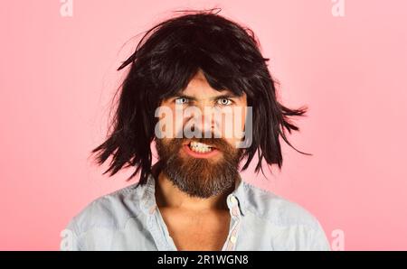 Homme barbu dans perruque noire. Portrait de l'homme en colère avec barbe et moustache en perruque noire. Mec mal aux cheveux noirs. Mâle barbu dans perruque. Homme en periwig Banque D'Images