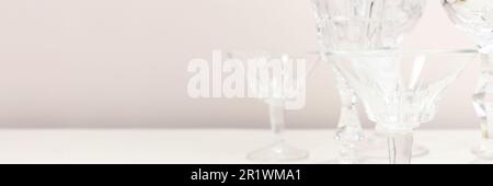 Bannière avec verres en cristal devant un fond beige. Concept minimal. Banque D'Images
