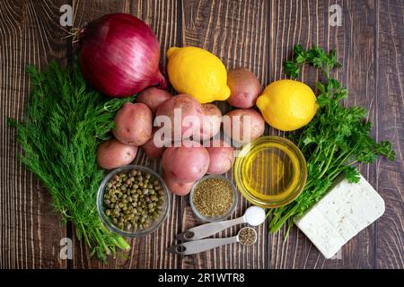 Salade grecque de pommes de terre Ingrédients sur une table rustique en bois: Pommes de terre rouges pour bébés, fromage feta et autres ingrédients pour un plat d'accompagnement grec végétarien Banque D'Images