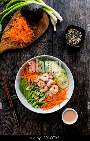 Bols à sushis aux crevettes avec riz au chou-fleur et mayonnaise épicée : bol de crevettes, avocat, carotte, servi comme bols à sushis de style japonais Banque D'Images