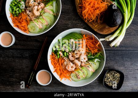 Bols de sushis à la crevette avec riz au chou-fleur et mayonnaise épicée : bols de crevettes, avocat, carottes, et servis comme bols de sushis de style japonais Banque D'Images