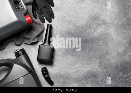 Composition de pose à plat avec produits de nettoyage pour voitures, gants et canister avec huile moteur sur table gris clair. Espace pour le texte Banque D'Images
